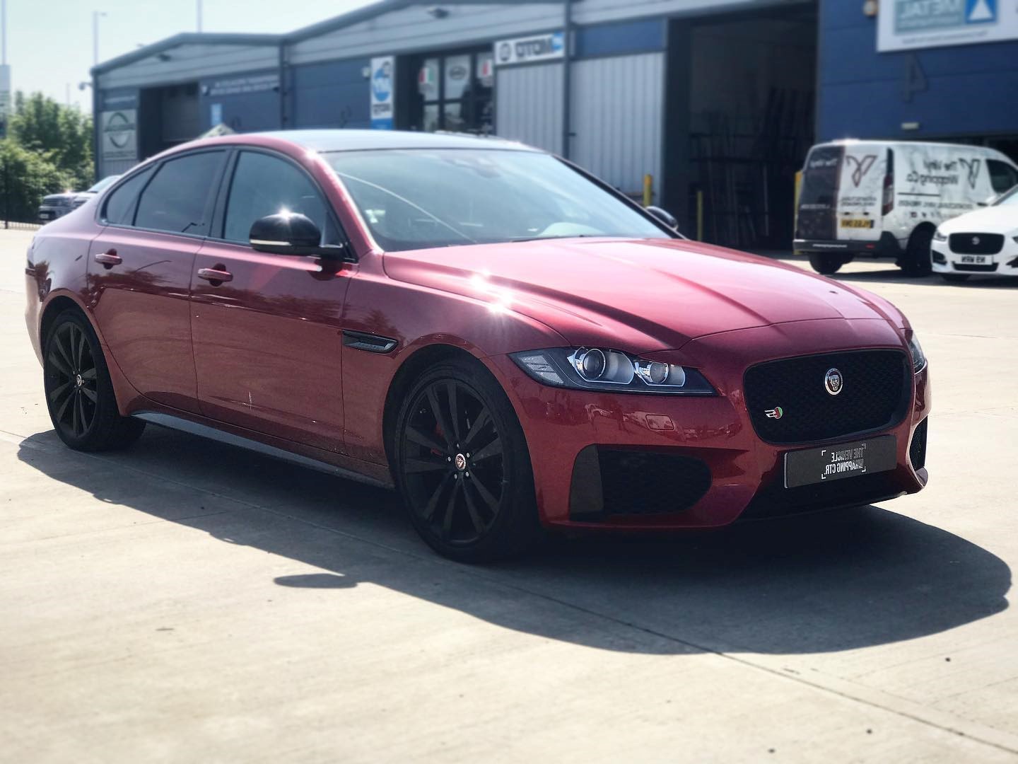 A beautiful red car enjoying its new warp outside The Vehicle Wrapping Centre garage.