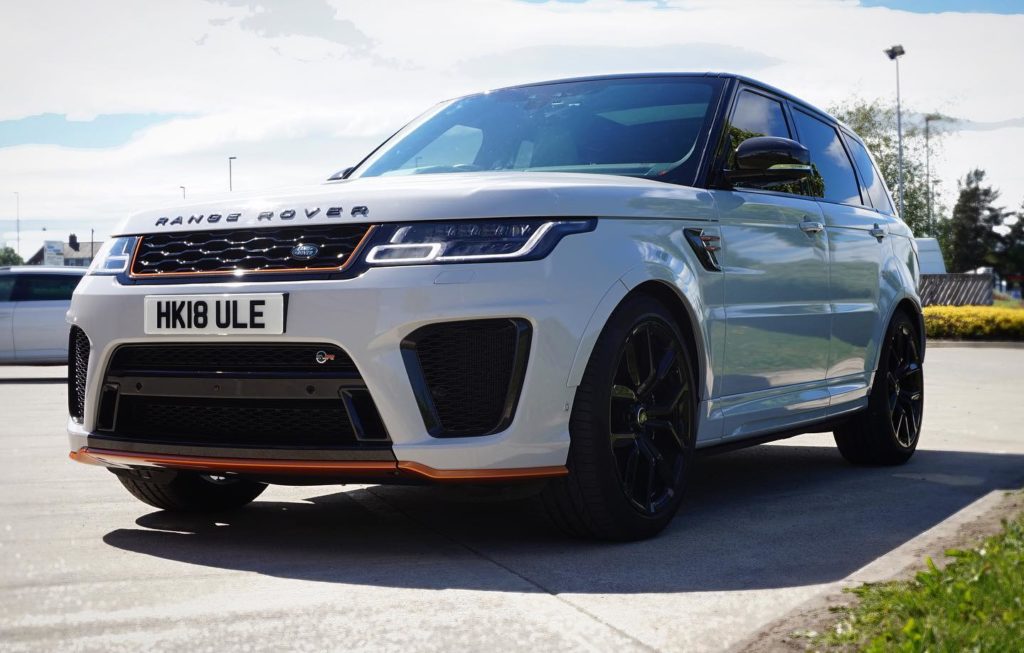 A picture of a Range Rover with beautiful new vinyl wrap in white with orange detailing.