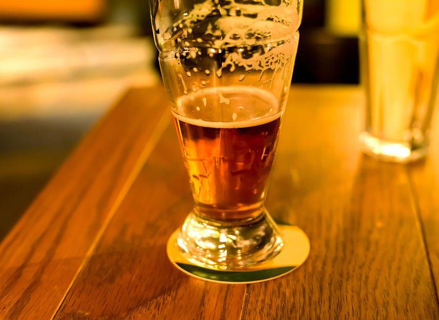 glass of foamy beer drunk delicious amber stands on a wooden table