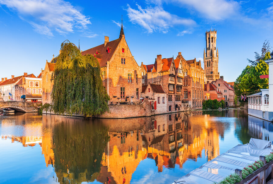 A reflective canal in Bruge during a beautifully clear and sunny day.