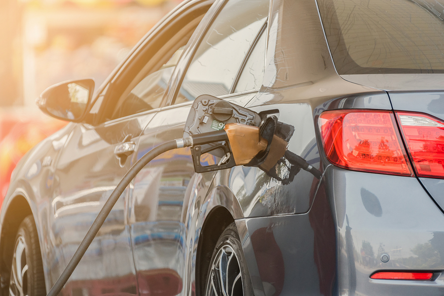 Small silver car refuelling at the gas station. Car refueling on petrol station. Fuel pump with gasoline. Car refueling on a petrol station. Car refueling on a petrol station closeup.