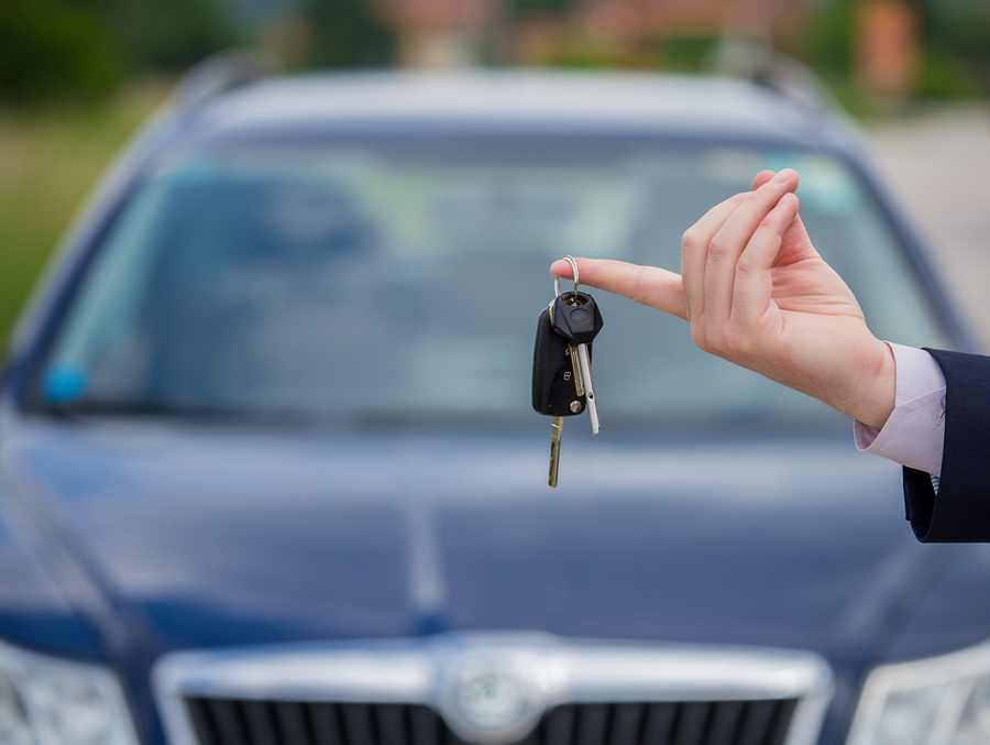 Selling a car, the seller gives the car keys to the buyer, buying a car, buying a new car with a smile